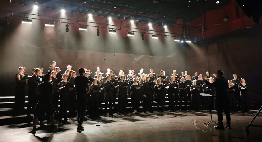 The Nordic Choir Expedition videonauhoitus Tukholmassa. Kuvassa laulava kuoro dramaattisessa valaistuksessa, takana tumma tausta.