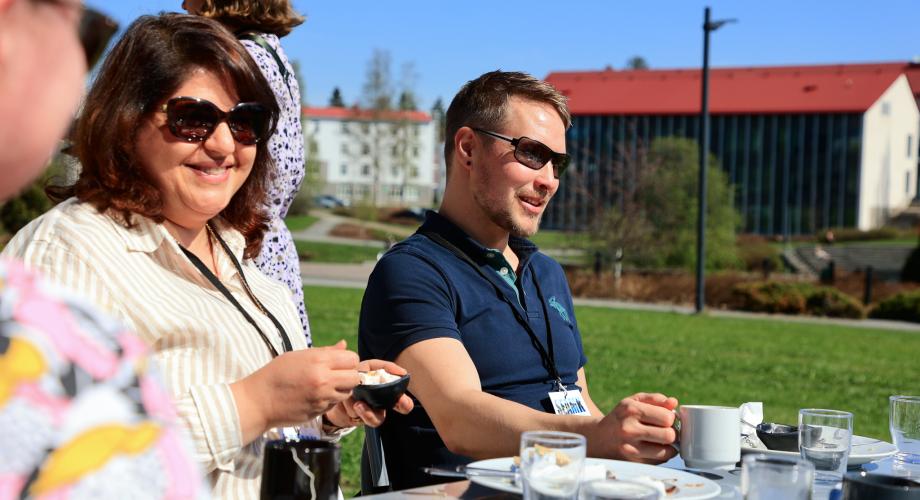 Tapahtuman osallistujia nauttimassa auringosta ulkona.