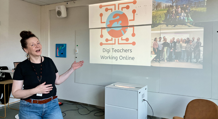 Project coordinator in front of a screen in a classroom.