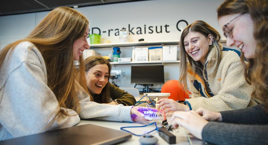Neljän opiskelijan ryhmä tekee yhteistyötä. 