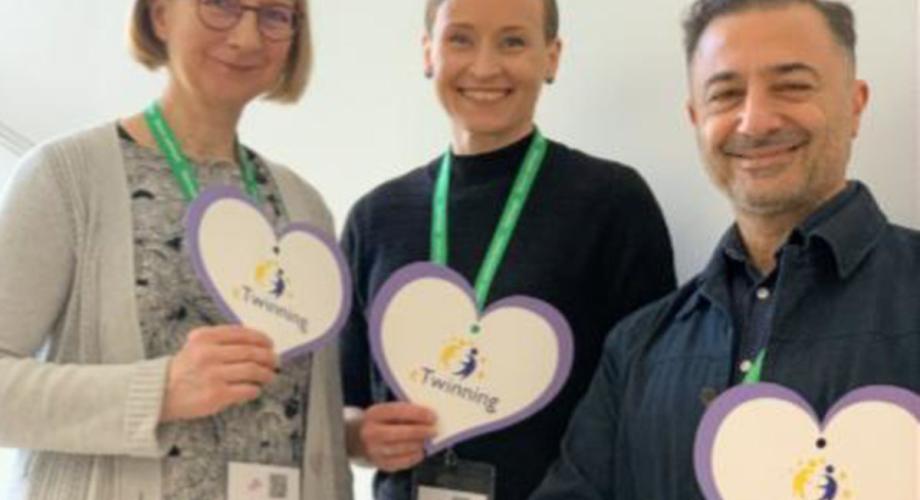 eTwinning-innovaattorit 2026, kolme aikuista ihmistä vierekkäin pahviset sydämet kädessä