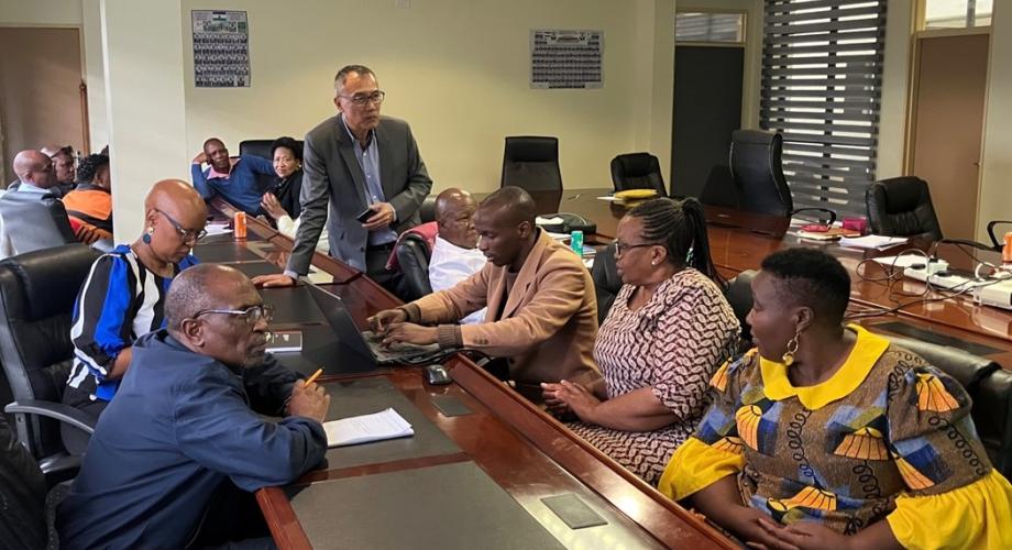 Ministry officials are sitting around a table and working together.
