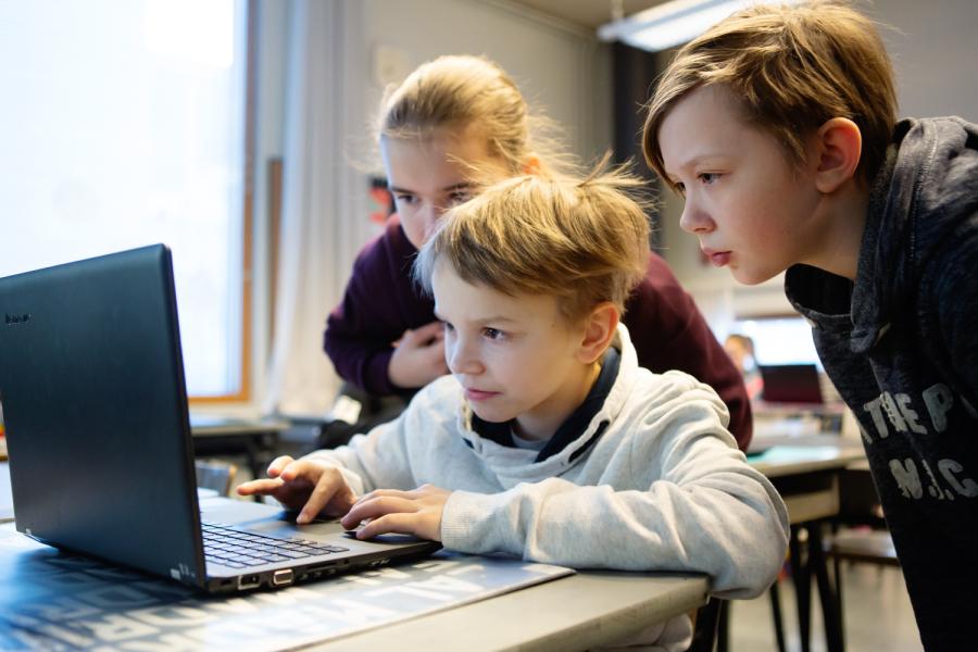 Three children looking at a laptop screen