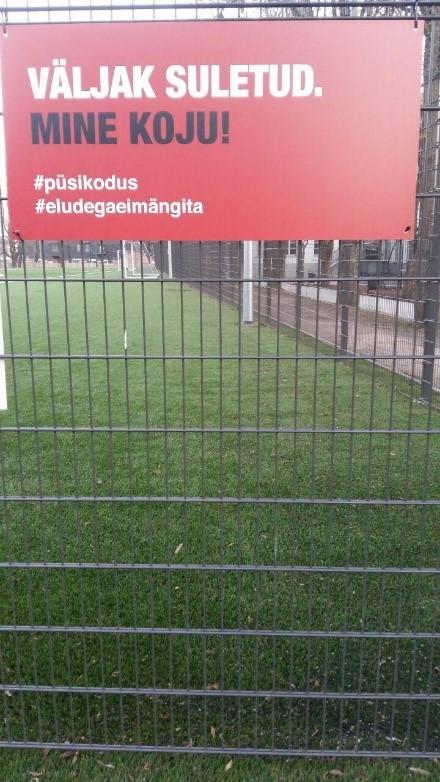 Koronaviruksesta varoittava kyltti nurminkentän laidalla Tartossa
