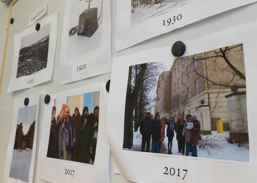 Kuvia seinällä, joiden alla on vuosilukuja.