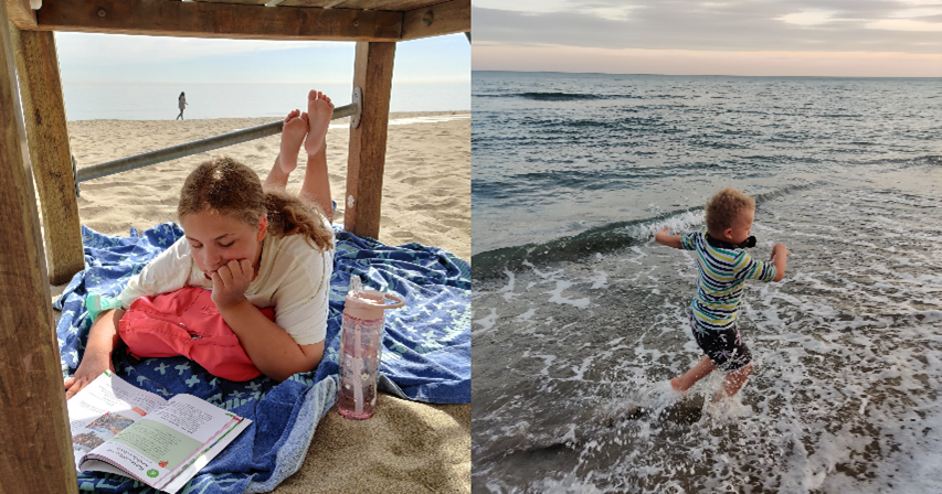 A girl is reading a school book on the beach and a boy is playing in the sea.