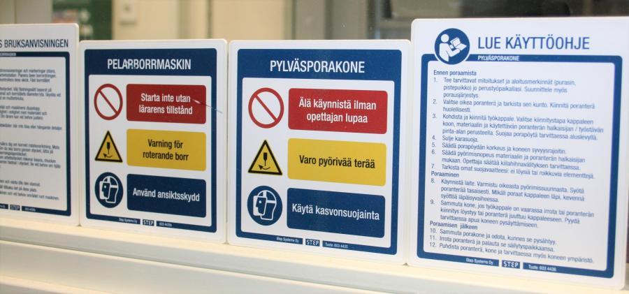 Kuvituskuva. Useissa käsityön oppimisympäristön koneissa ja laitteissa on kattavia turvallisuusohjeita, jotka tulee olla työtiloissa näkyvästi esillä ja sijoitettuna laitteiden viereen.