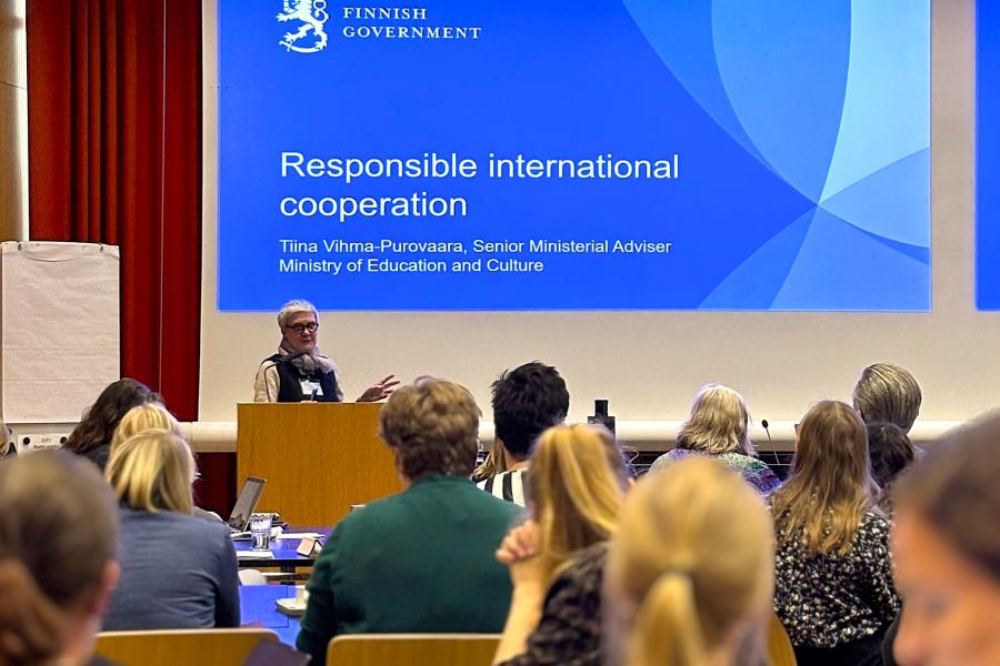 Osallistujat kuuntelevat opetus- ja kulttuuriministeriön edustajan puhetta.