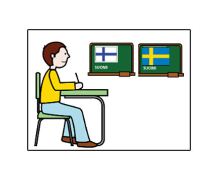 Poika istuu pulpetin ääressä. Seinällä on suomen ja ruotsin liput.