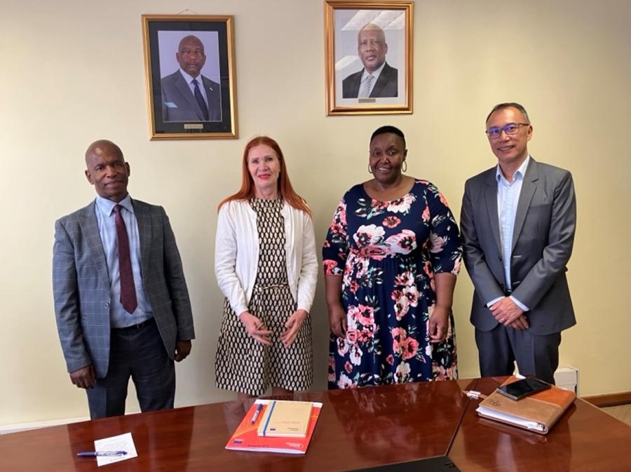 Four people standing together: the ministry officials from Lesotho, and two RTIA technical leads for education.