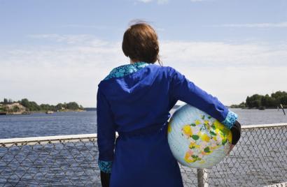 Kuvituskuva, tyttö jolla maapallo kainalossa