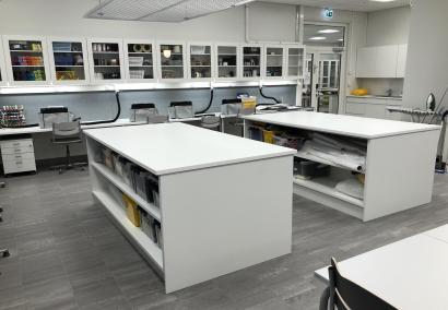Kuvituskuva. Kankaanleikkauspöydillä oppilailla on mahdollisuus levittää isoja kangaspakkoja ja työskennellä ergonomisesti seisten.
