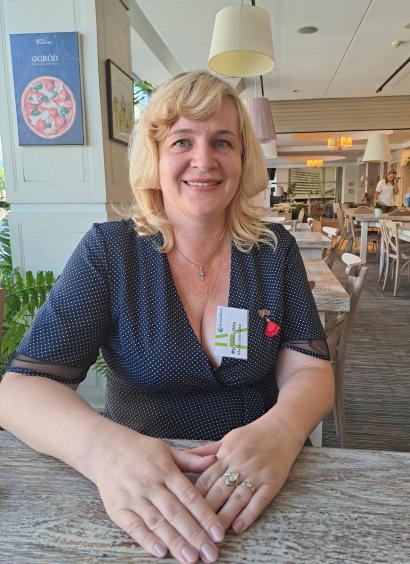 Blonde woman sitting at a table smiling